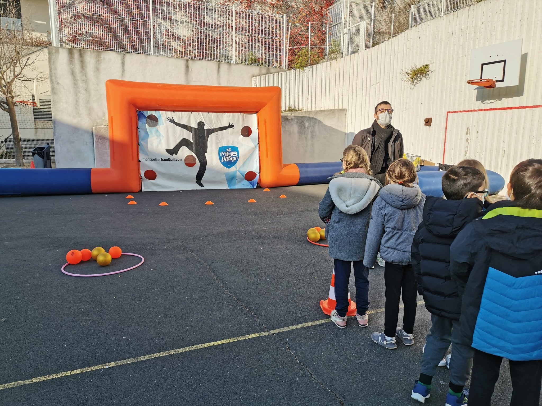 Des enfants jouent au lancer de ballon.