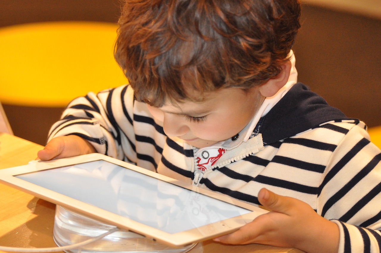 Un enfant qui lit sur une tablette numérique