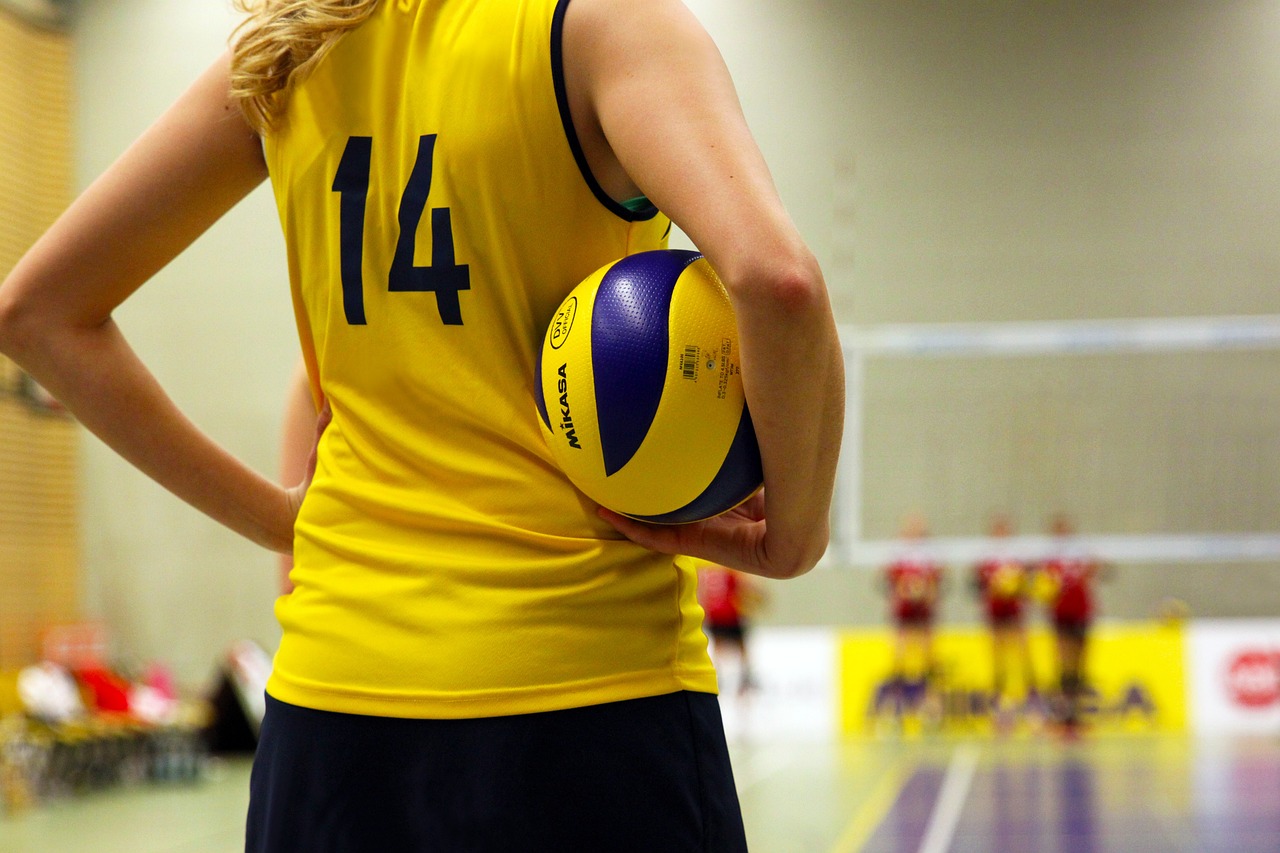 Une joueuse de volley-ball qui tient un ballon sous son bras