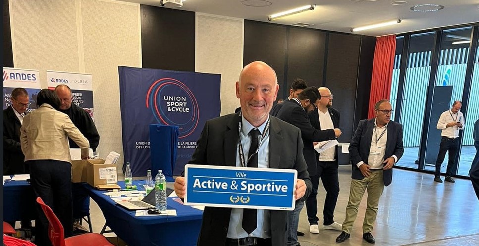 Le Maire posant avec le panneau Ville active et sportive