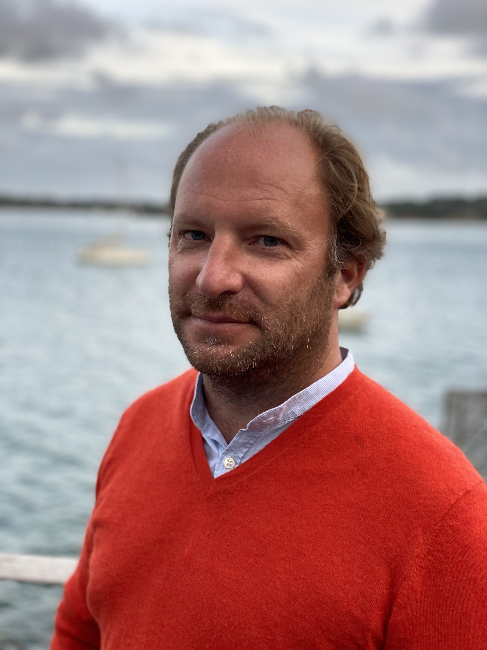 photo de Charles Lebrec, en pull rouge, devant la mer