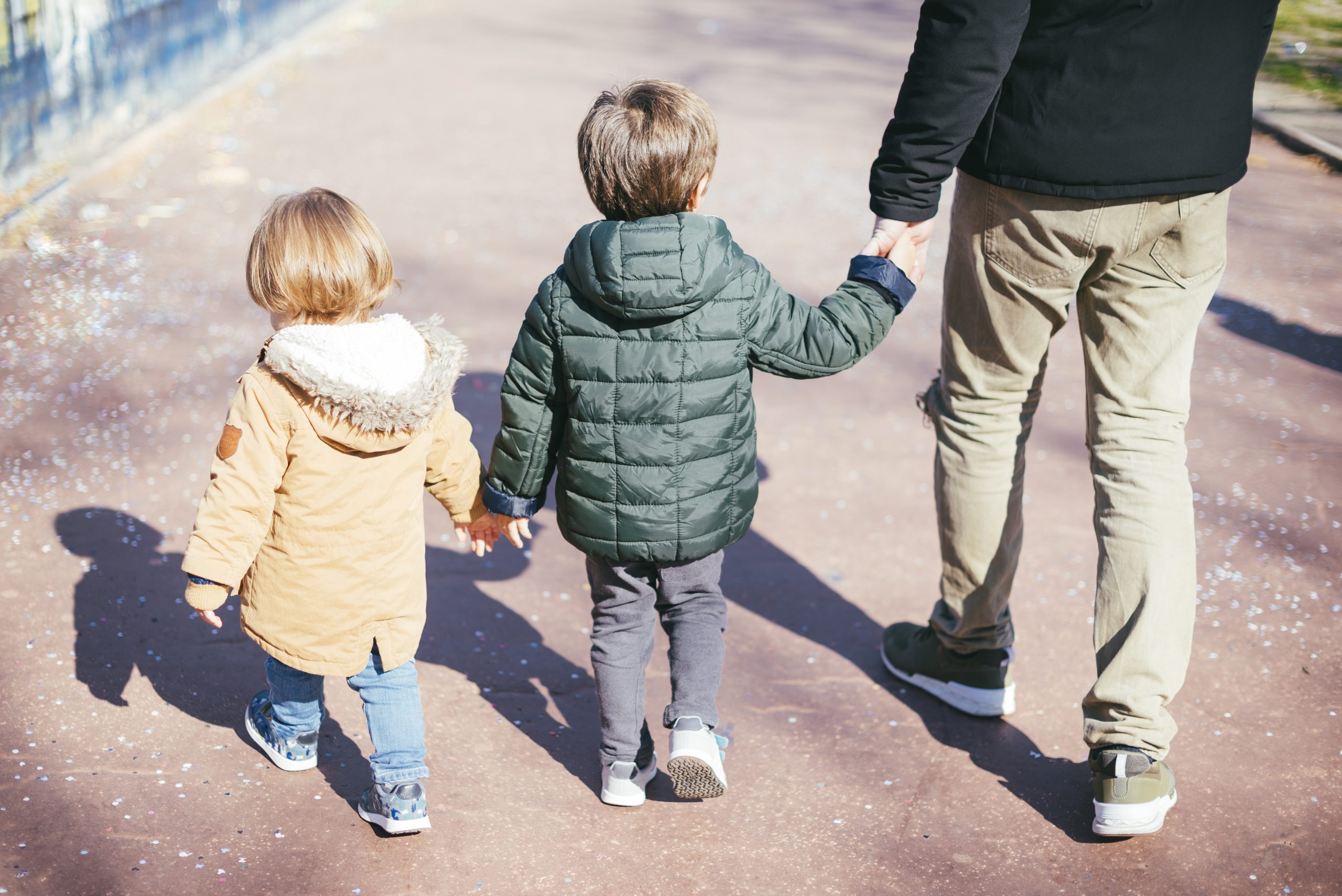 Un homme qui ses enfants par la main