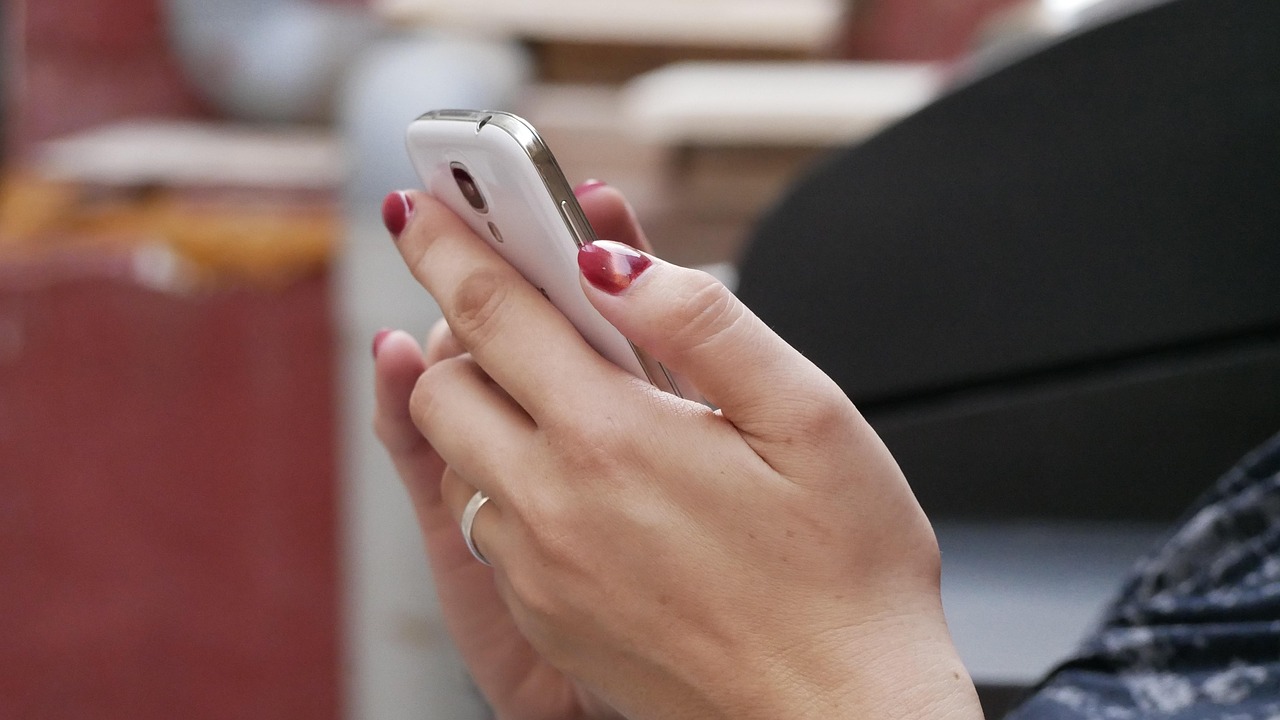 Un gros plan sur des mains de femmes tenant un téléphone