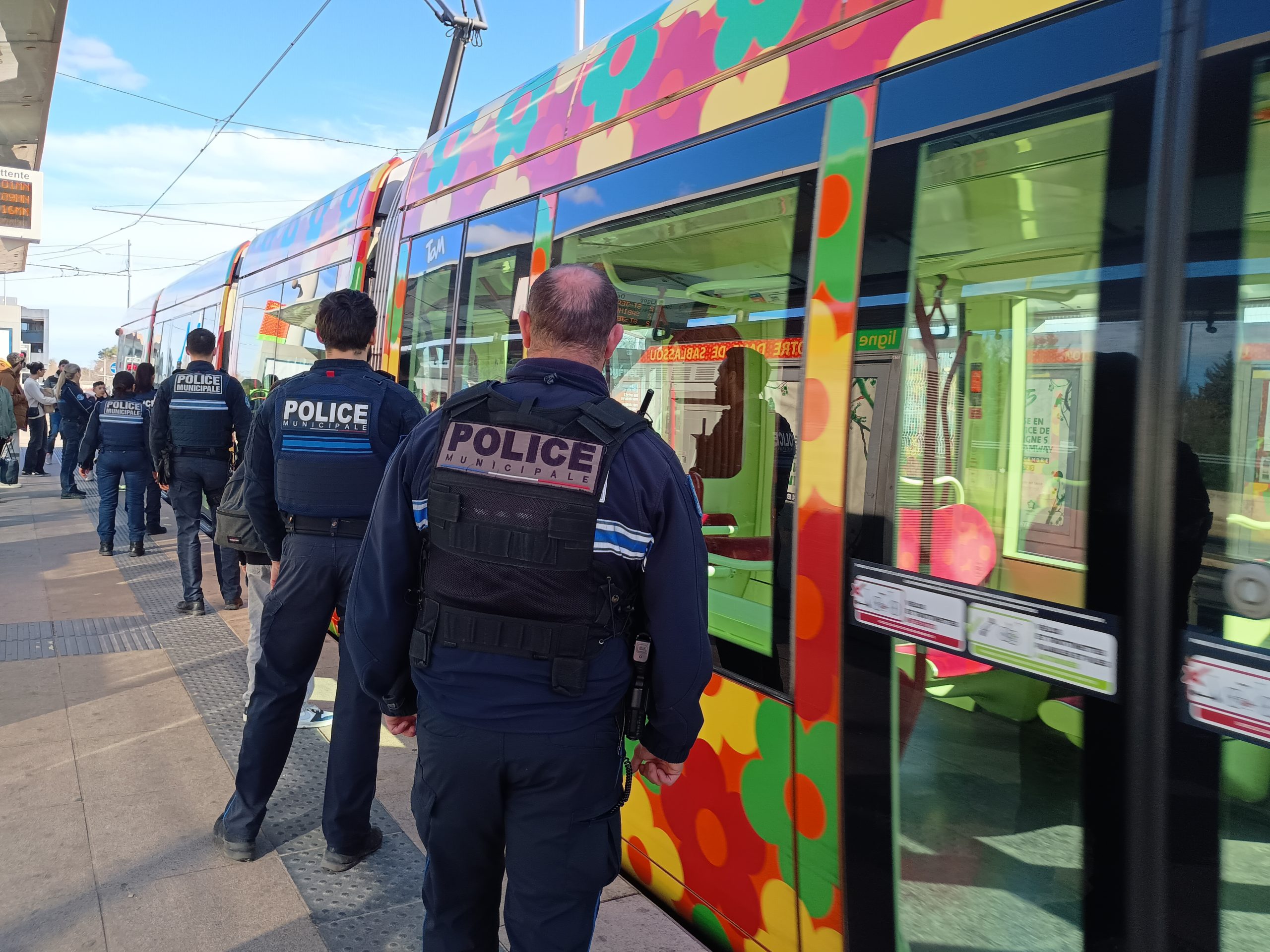 Des policiers municipaux en tenue devant le tram à fleurs de la ligne 2 de tramway